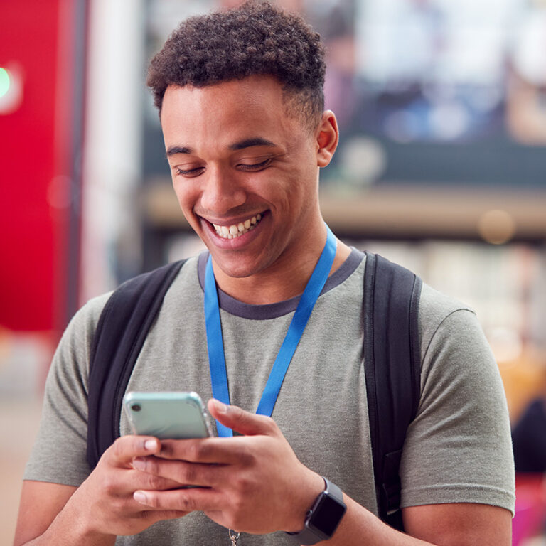 Student smiling and looking at cell phone
